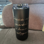 Black tumbler with gold text on a brown couch