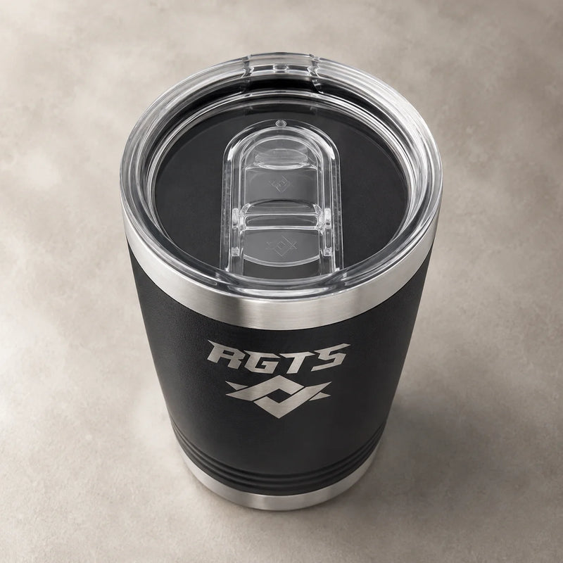 A black insulated tumbler with a clear lid and silver rim, featuring the white 'RGTS' logo and geometric emblem on the front, set against a textured gray background.