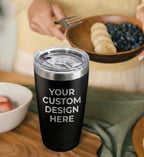 Black tumbler with 'Your Custom Design Here' text in a kitchen setting with fruit bowls.